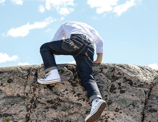 Barn klättrar på klippor i slitstarka jeans från Ossoami